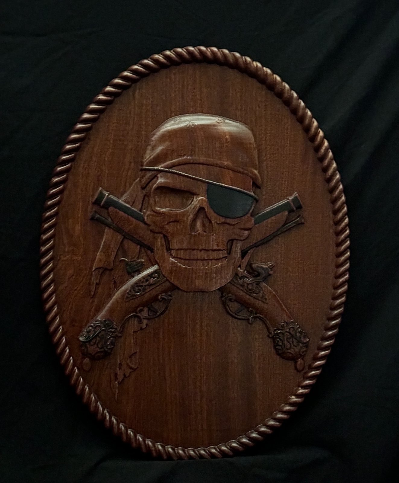 Detailed custom skull and crossed firearms CNC wood carving by Singed Impressions